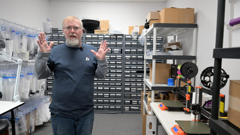 Dave standing next to 3D printers on the Crestwood Industries shop floor